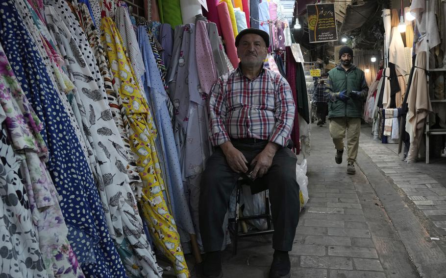 A man sits in a market.