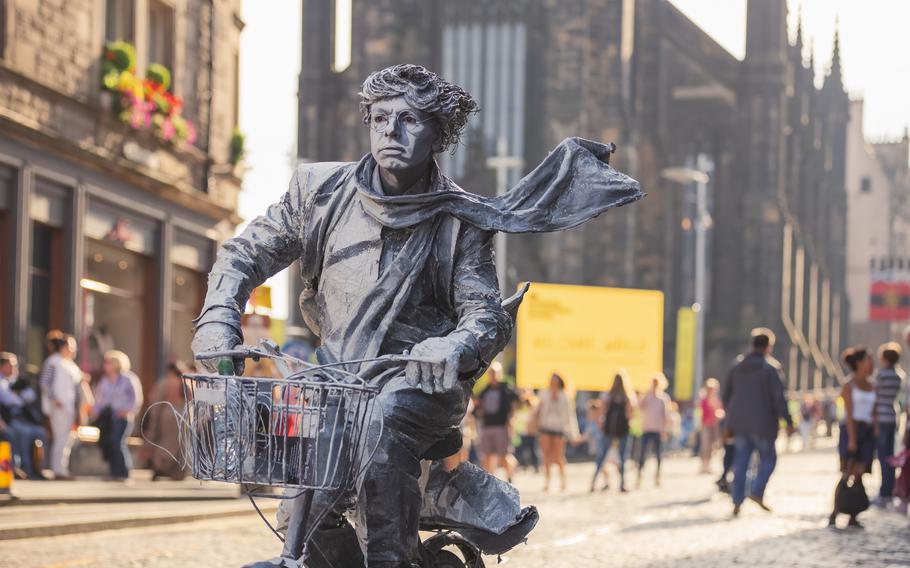 A street performer poses as a living statue in front of Tollbooth Kirk on the Royal Mile during a past version of the Edinburgh Festival Fringe.