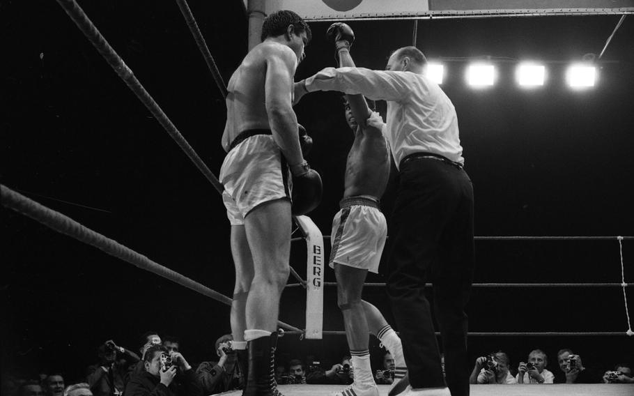 Referee Teddy Waltham stops the fight at the 1:30 minute of round 12 as a dazed looking Mildenberger watches Ali hoist his right arm up in victory as he retained his heavyweight title with a technical knockout.