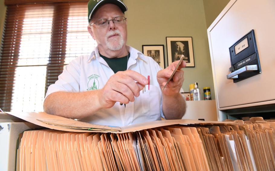 Garrity stand behind a stack of files.