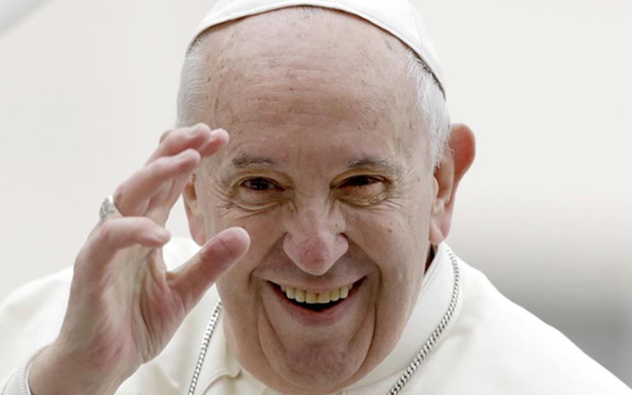 Pope Francis smiles and waves