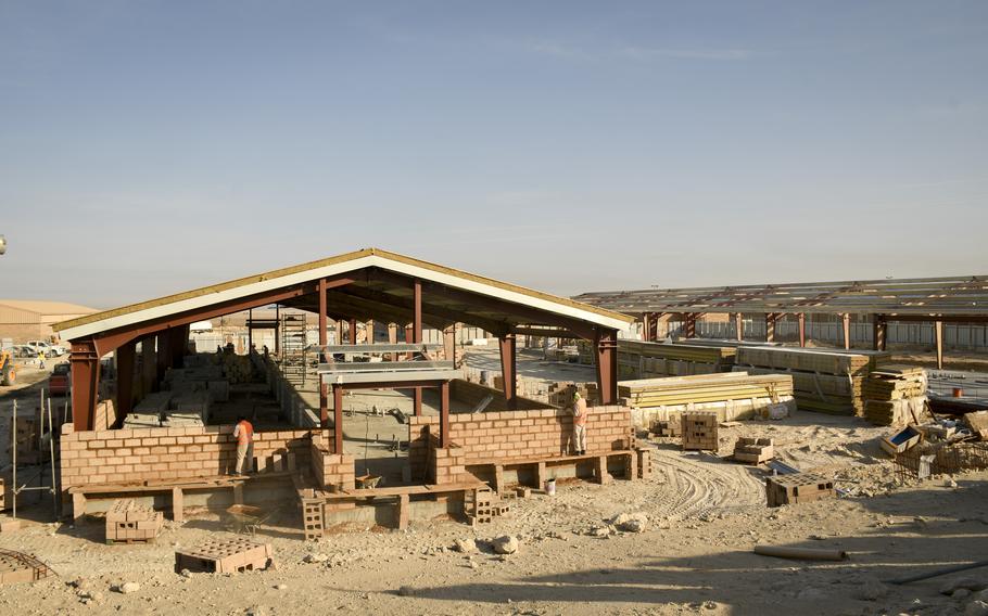 Contracted workers lay cinder blocks as part of a project to build hardened dorms for troops at Ali Al Salem Air Base in Kuwait on Nov. 28, 2022. The dorms will have more protection against missile strikes, base engineers said.