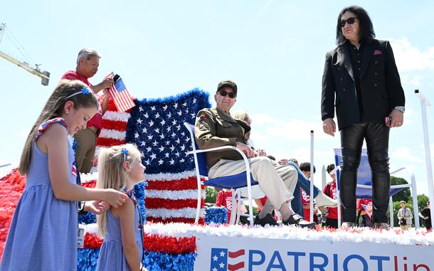 Two young girls talk to Gene Simmons and their great-grandfather, Hal Urban.