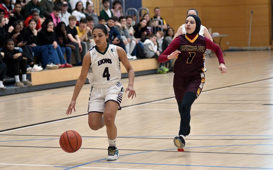 AFNORTH junior Selah Skariah dribbles on the fast break while Baumholder sophomore Kawther Al’Qurashi chases her down during pool-play action of the DODEA European basketball championships on Feb. 14, 2024, at the Wiesbaden Sports and Fitness Center on Clay Kaserne in Wiesbaden, Germany.