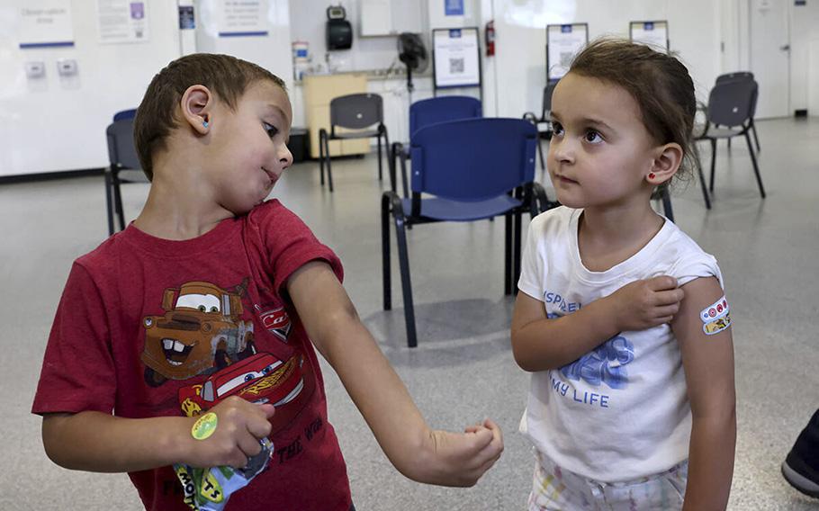 Three-year-old twins Luca, left, and Quincy Yacoub show off their Band-Aids after getting a COVID-19 vaccine from KJ Dionisio at the Southern Nevada Health District in Las Vegas ON June 22, 2022. 