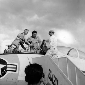 Marine pilot Klingman (left) helps Rep. Daniel K. Inouye (D-Hawaii) climb out of a F9F8T jet trainer at Itazuke Air Base. Staff Sgt. Robert L. Bingham, 6143rd Operations Squadron, assists. Congressman Inouye came to Japan to visit visited the mountain village of Yokoyama — the birthplace of his father and where some of his uncles and cousins still live. Rep. Inouye is the first Japanese American to serve in Congress.