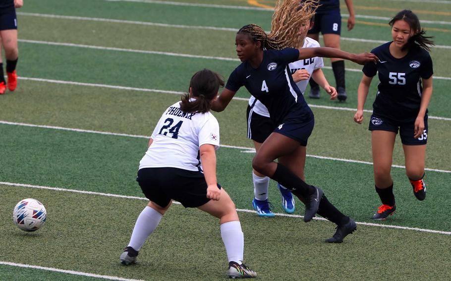 Osan's Tatiana Lunn darts around Korea International defender Jangee Portillo during Saturday's Korea girls soccer match. The Phoenix won 6-2.