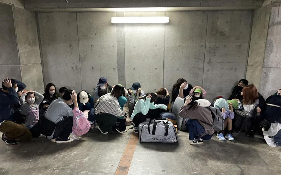 People take shelter during a missile evacuation drill in Naha, Okinawa, Jan. 21, 2023.