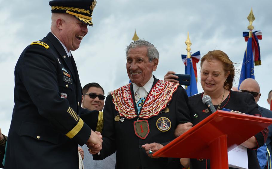 Charles Shay, center, accompanied by Marie-Pascale Legrand, right, shakes hands with Maj. Gen. Timothy McGuire at a ceremony in Saint Laurent sur Mer, France, June 5, 2017.  