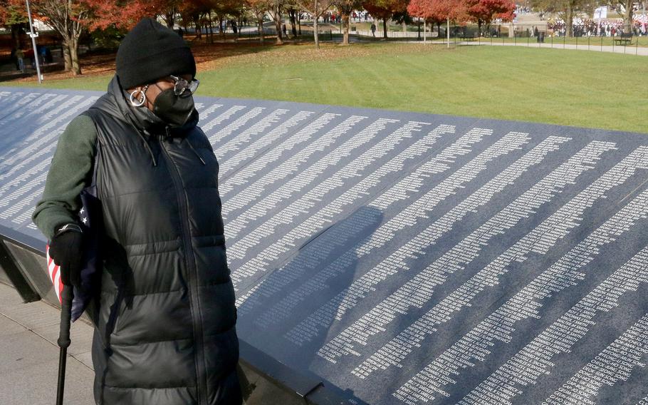 A visitor looks at names on the Korean War Memorial.