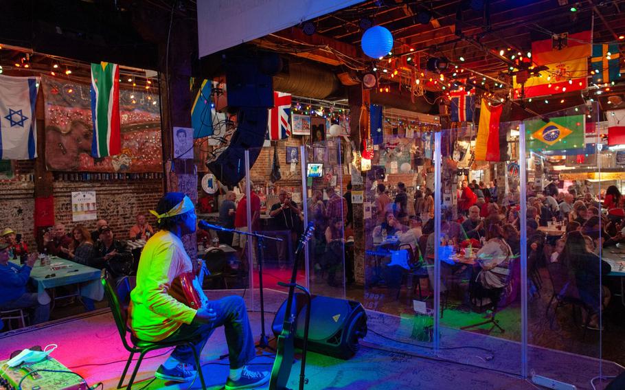 A musician performs behind plexiglass inside a venue at the Juke Joint Festival in Clarksdale, Miss., on April 17, 2021.