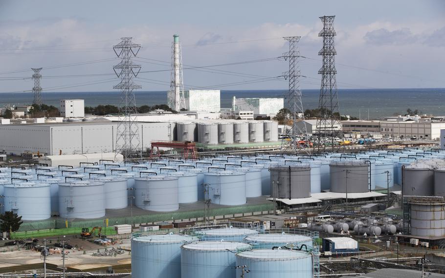 Nuclear reactors of No. 5, center left, and 6 look over tanks storing water that was treated but still radioactive at the Fukushima Daiichi nuclear power plant in Okuma town, Fukushima prefecture, northeastern Japan, Feb. 27, 2021.