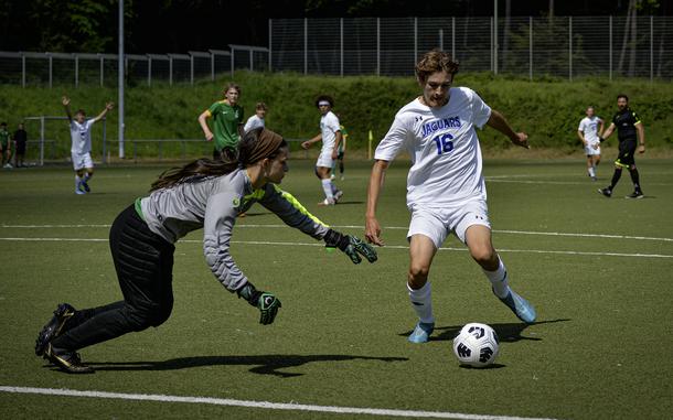 Alconbury goalkeeper Abigail Hudson leaps ain front of Sigonella's Joseph Eck to stop his goal attempt during the 2024 DODEA European Soccer Division III Championships in Landstuhl, Germany, on May 20, 2024. Eck managed to navigate past her to sink the ball.