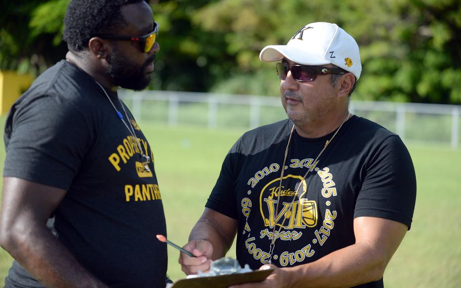 Kadena head coach Sergio Mendoza, right, and his assistant Antiwon Tucker discuss plays during practice.