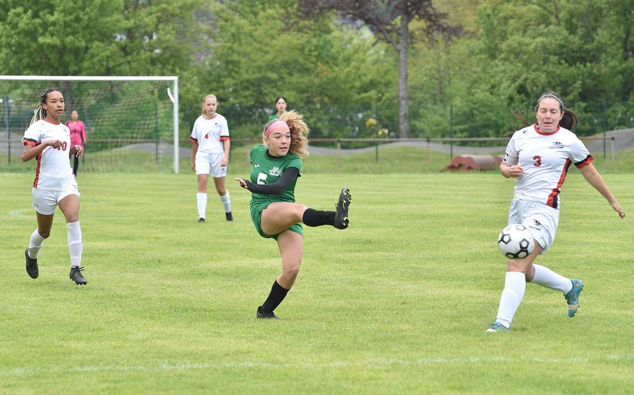 Naples midfielder Emma Heavey shoots during the first half of a Division II semifinal against American Overseas school of Rome at the DODEA European soccer championship on May 17, 2023, at VfR Baumholder's stadium in Baumholder, Germany. At right is the Falcons' Mia Lambert.