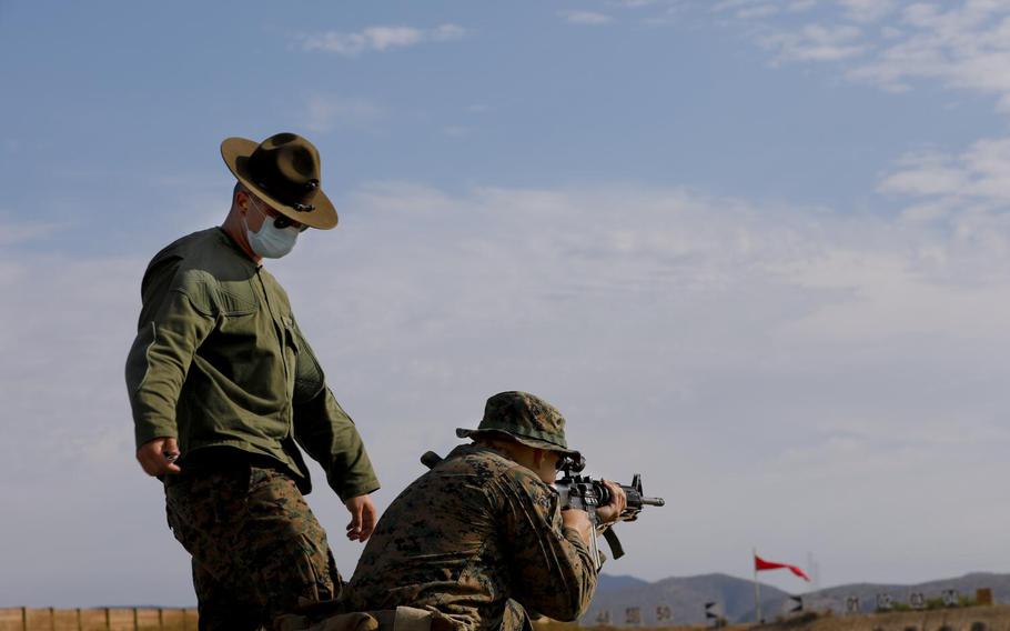 A shooting instructor observes recruit Garrett Glasson, 21, at Camp Pendleton, Calif., in August 2020.