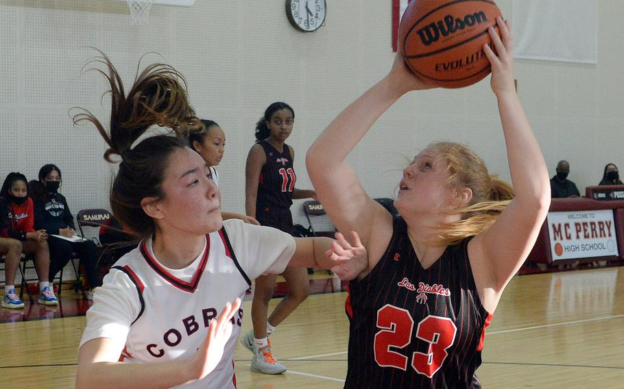 Nile C. Kinnick's Davan Webster looks to shoot against E.J. King's Aileen FitzGerald during Friday's DODEA-Japan girls basketball game. The Red Devils won 60-34.