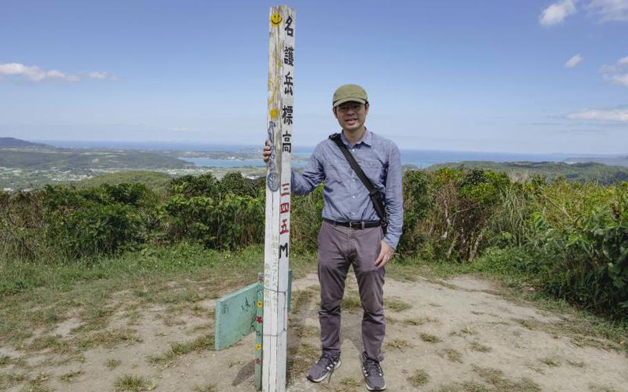 Shoji Kudaka, a Stars and Stripes writer, is standing on the summit of Nago-dake.