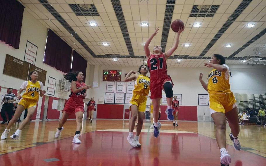 Nile C. Kinnick's Jasmine Pho drives to the basket against Robert D. Edgren's A'mya Ross, Maliyah Magat and Zalea Washington as teammate Kotone Turner looks to help during Saturday's DODEA-Japan girls basketball game. The Red Devils won 41-16.