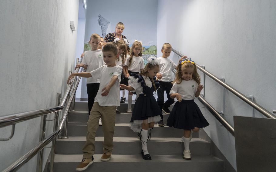 Youngsters walk down stairs to their underground school.