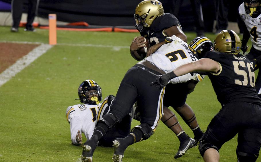 Missouri defensive lineman Darius Robinson (6) is unable to stop Army running back Jakobi Buchanan, center top, who reached the end zone for a touchdown on a running play in the second half of the Armed Forces Bowl NCAA college football game in Fort Worth, Texas, Wednesday, Dec. 22, 2021.