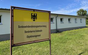 A German-language sign stands in front of a building.