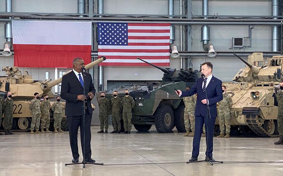 U.S. Defense Secretary Lloyd Austin, left, and Polish Defense Minister Mariusz Blaszczak address troops of both nations during a visit to Powidz Air Base, Poland, Feb. 18, 2022. 
