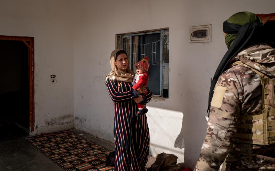 A resident of the Khishman neighborhood in Hasakah, Syria, answers questions from a fighter with the U.S.-backed Syrian Democratic Forces during a house-to-house search for weapons or documents potentially belonging to ISIS militants on Feb. 1. 