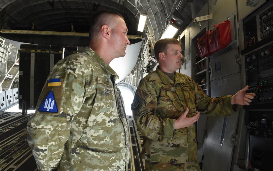 Staff Sgt. Breck Martin, an air adviser and C-17 loadmaster with the 435th Contingency Response Support Squadron, shows Col. Dmytro Lapitskyi, a Ukraine air force air traffic controller and former bomber pilot, the hydraulic system in the back of a C-17 aircraft at Ramstein Air Base, Germany. 