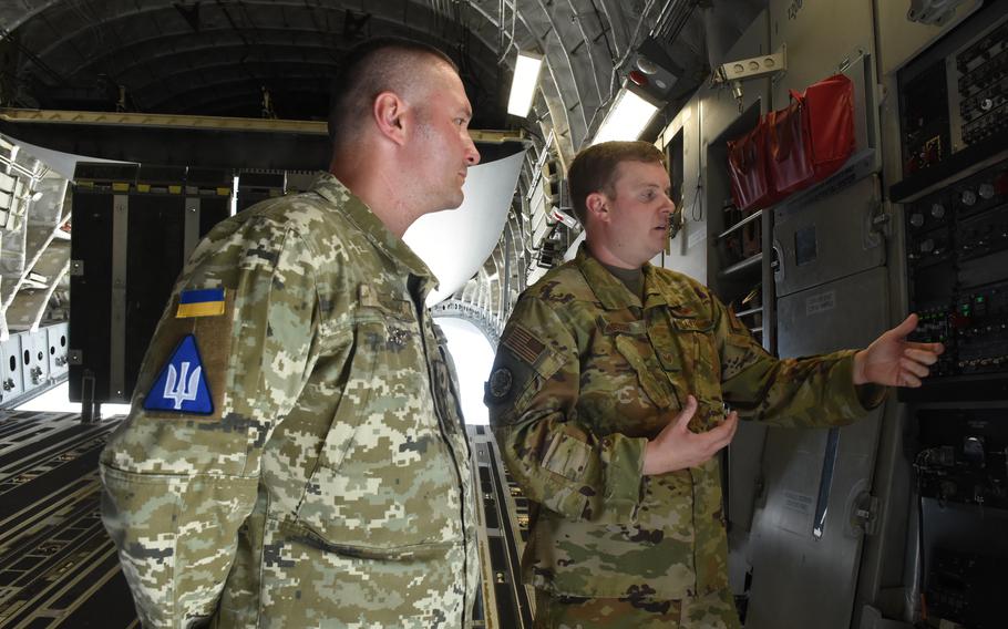 Staff Sgt. Breck Martin, an air adviser and C-17 loadmaster with the 435th Contingency Response Support Squadron, shows Col. Dmytro Lapitskyi, a Ukraine air force air traffic controller and former bomber pilot, the hydraulic system in the back of a C-17 aircraft at Ramstein Air Base, Germany. 