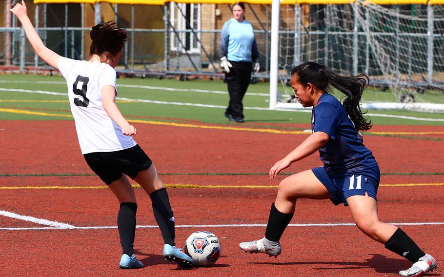 Daegu’s Shawna Jang readies to boot the ball against Osan’s Margaux Edquid during Saturday’s DODEA-Korea soccer match. The Warriors won 3-2.