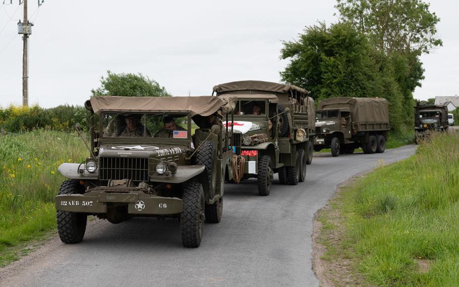 Soldiers ride in a vintage military vehicle.