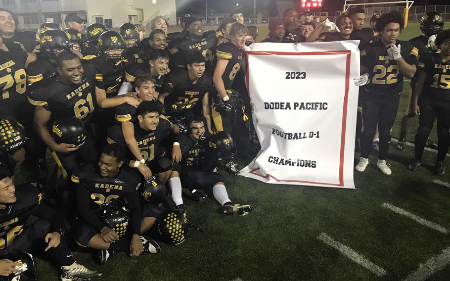 Kadena players gather 'round the Far East Diivision I football championship banner.