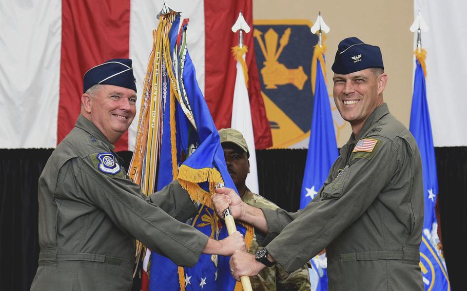Col. Andrew J. Campbell, outgoing commander of 374th Airlift Wing passes the guidon to Lt. Gen. Ricky N. Rupp, commander, U.S. Forces Japan and 5th Air Forces, during a change-of-command ceremony at Yokota Air Base, Japan, June 23, 2022.