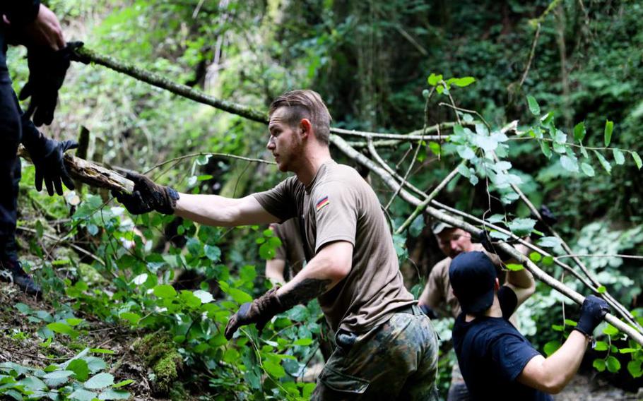 German army Staff Sgt. Andrej Lucenko removes tree branches from a stream with 21st Theater Sustainment Command soldiers and others in St. Goar, Germany, July 11, 2022. 