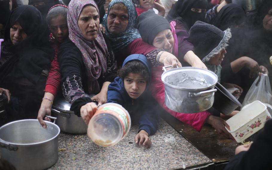 Palestinians line up for free food distribution during the ongoing Israeli air and ground offensive in Khan Younis, Gaza Strip, Friday, Feb. 2, 2024.