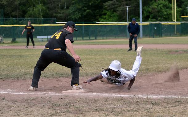 Naples junior Jeramiah Robinson drives back to the bag, while Vicenza first baseman Zach Alderson tries to apply the tag during the Division II/III final at the 2025 DODEA European baseball championships on May 23, 2025, at Southside Fitness Center on Ramstein Air Base, Germany.