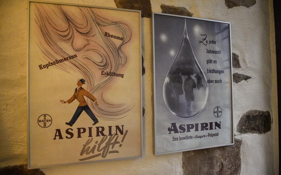 These posters hang on the wall of the German Pharmacy Museum in Heidelberg, Germany. They advertise for the Bayer company's aspirin, extolling of their benefits against headaches, colds and rheumatism.