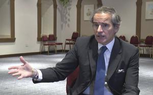 IAEA Director General Rafael Mariano Grossi wears a suit and gestures with one hand during an interview.