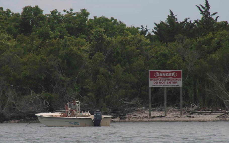 A couple sits illegally anchored in front of Brown’s Island in the Atlantic‐Intracoastal Waterway on May 25, 2018. The recent discovery of a hidden 250-pound bomb has prompted a new round of warnings from the Marine Corps for people to avoid setting foot on Brown’s Island on the North Carolina coast.