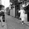 Two Japanese boys watch as Bill leaves the Soba shop in Shinjuku for another delivery. 