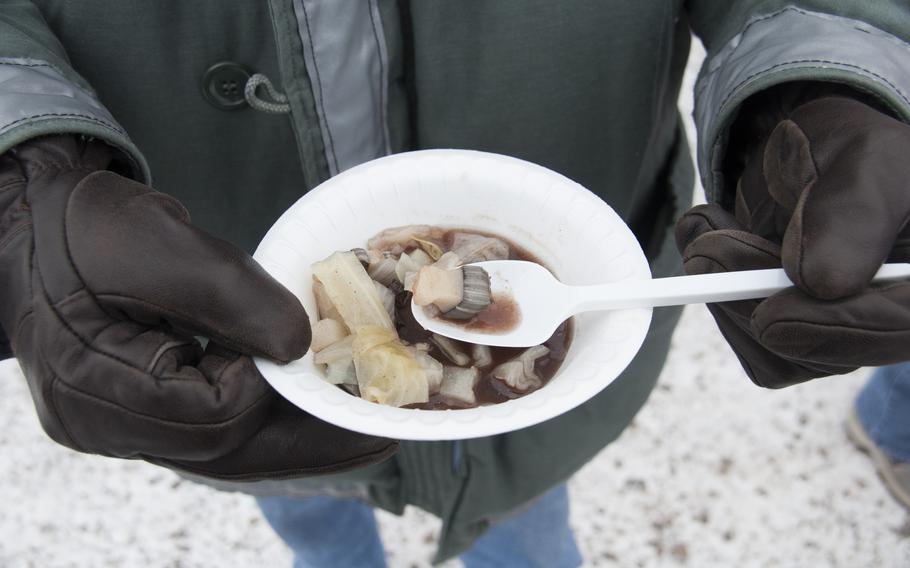 A contractor on Thule Air Base grabs a bowl of narwhal soup during a weekend of demonstrations of Inuit life. Seal stew was also available, and one could purchase slabs of beluga and musk ox.