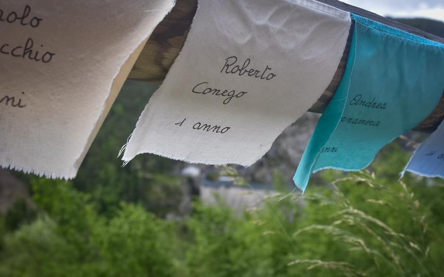 Almost 500 pieces of cloth line a fence overlooking the Vajont Dam near Longarone, Italy. Each one lists the name of a child 15 or younger killed Oct. 9, 1963, when a landslide crashed into the reservoir at the dam, causing a wave of water that wiped out several villages. 