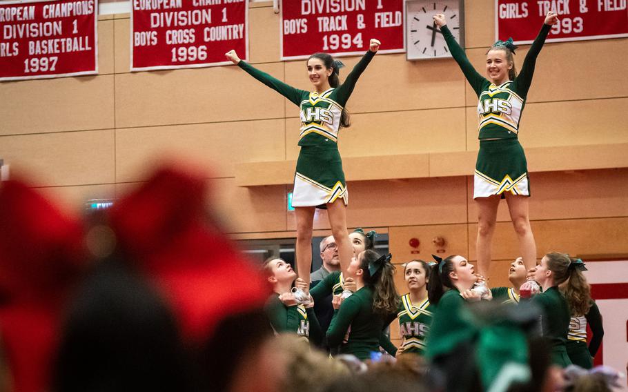 Cheerleaders from Alconbury High School hoist up Kylie Leach, left, and Althea Milionis during the 2023 DODEA-Europe Cheerleading Championships at Kaiserslautern High School on Friday, Feb. 18.