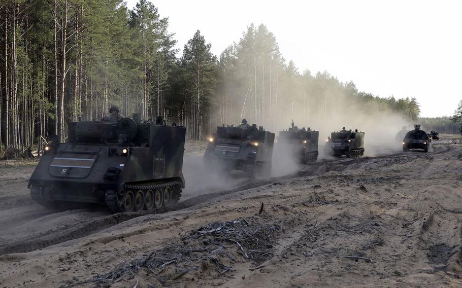 Pennsylvania Army National Guard soldiers drive vehicles from an area for pre-positioned stock May 10, 2022, in Pabrade, Lithuania. Initiatives on the table at the upcoming NATO summit in Madrid include more pre-positioned weaponry and air defenses.