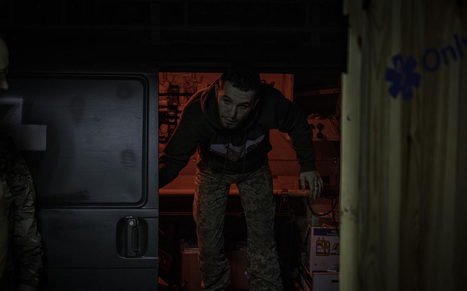 A red light shines in the doorway behind the Ukrainian serviceman.