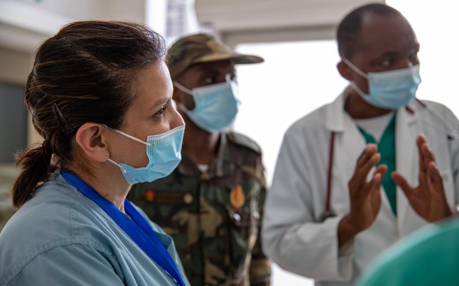 Capt. Claudia McDermott, left, commander of the 357th Forward Resuscitative Surgical Detachment, is briefed on emergency room procedures by Angolan army medical staffers at the Hospital Militar Principal in Luanda, Angola, on Nov. 8, 2022.