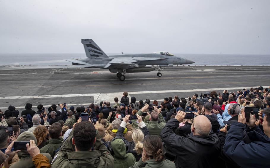Guests observe an air power demonstration on the flight deck of the USS Abraham Lincoln