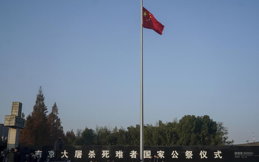 In this photo released by Xinhua News Agency, the Chinese national flag is flown at half mast as officials preparing for a memorial ceremony for the Nanking Massacre victims at the Memorial Hall of the Victims of the Nanjing Massacre by Japanese Invaders in Nanking, in eastern China's Jiangsu Province, Monday, Dec. 13, 2021. China on Monday marking the 84th anniversary of the Nanking Massacre, in which it says hundreds of thousands of civilians and disarmed soldiers were killed by Japanese soldiers in and around the former Chinese capital. 