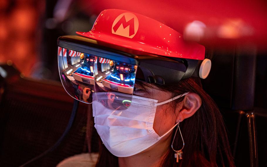 A rider wears themed augmented reality goggles on the Mario Kart ride during a media preview of the theme park at Universal Studios Japan in Osaka on March 17, 2021. 